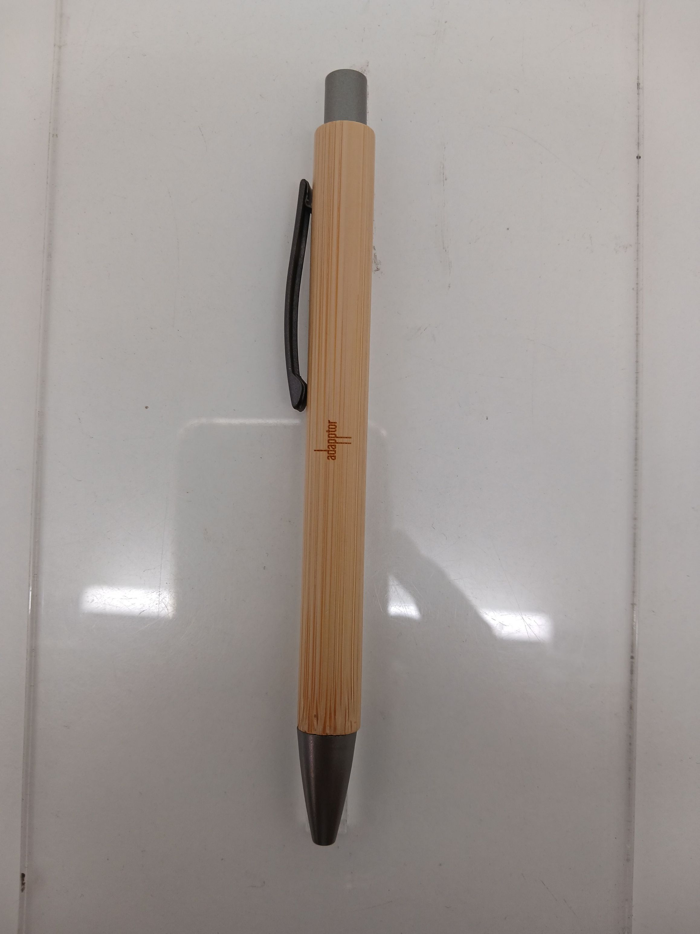 Bamboo click pen laser-engraved with the Adapptor logo